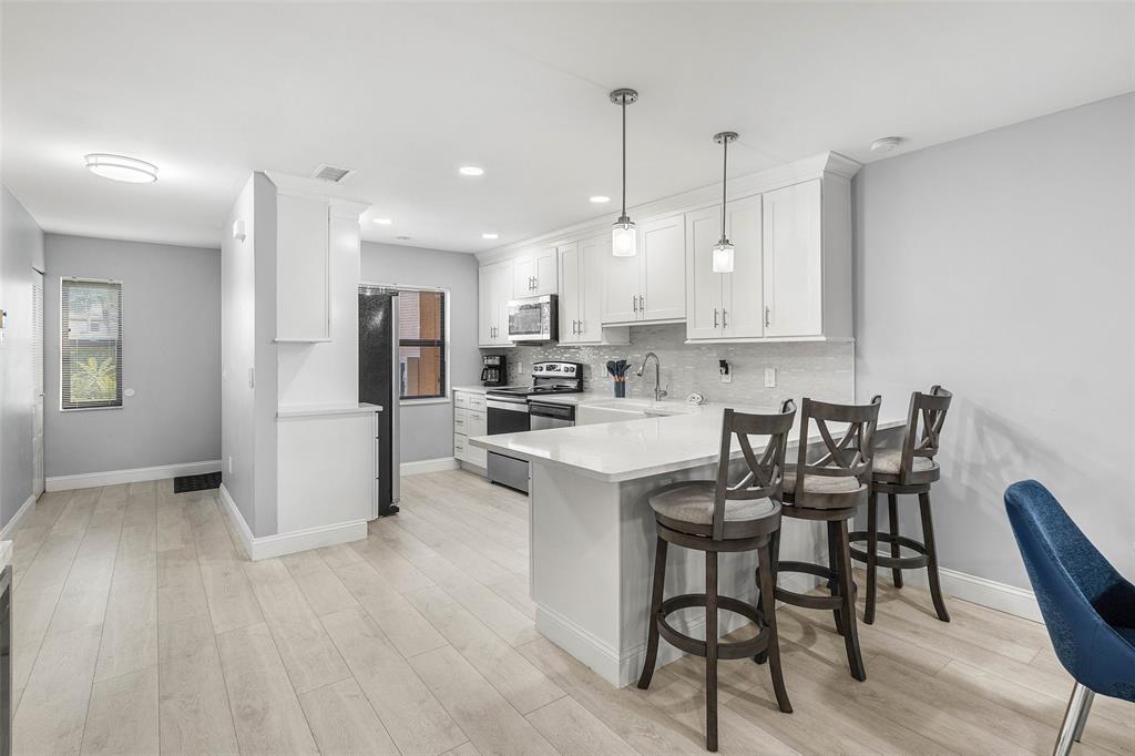 9286 Vista Del Lago, Unit E Boca Raton, FL 33428 - Photo 7 of 26 a view of kitchen with refrigerator and wooden floor