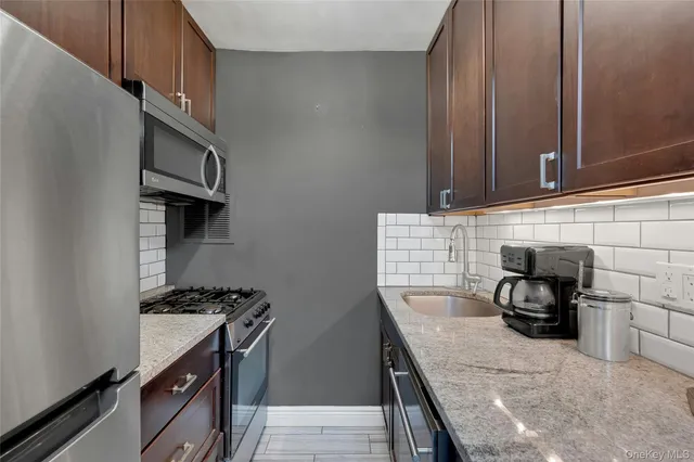 a kitchen with granite countertop a stove and a sink