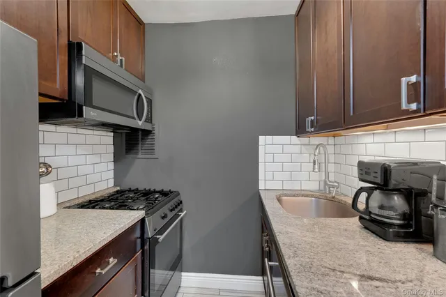 a kitchen with granite countertop a stove and a sink