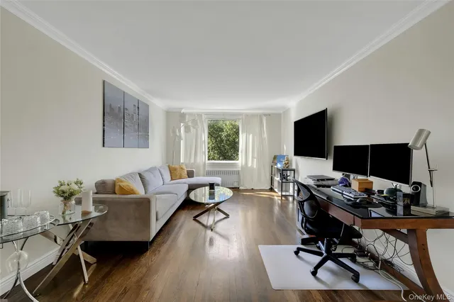 a living room with furniture a flat screen tv and a window