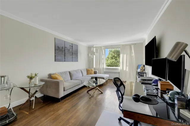 a living room with furniture a wooden floor and a flat screen tv