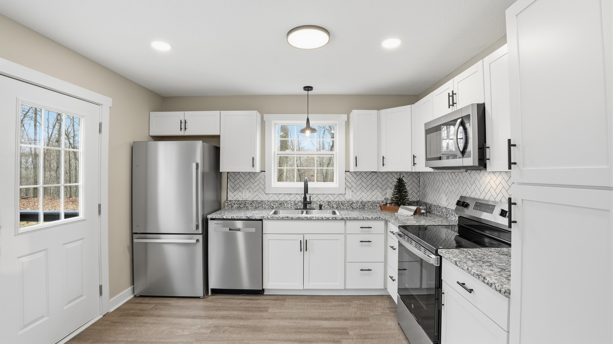 790 Preston Ridge Road Mulberry, TN 37359 - Photo 27 of 44 a kitchen with stainless steel appliances granite countertop a refrigerator a sink dishwasher a oven with white cabinets and wooden floor