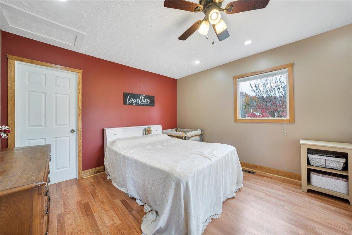 1122 Barberry Road Southeast Floyd, VA 24091 - Photo 8 of 39 a bedroom with a large bed a chandelier and a window