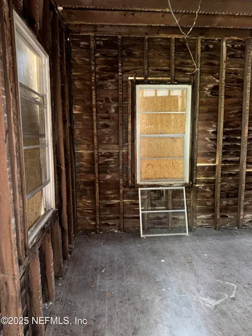 a view of an empty room with furniture and a window