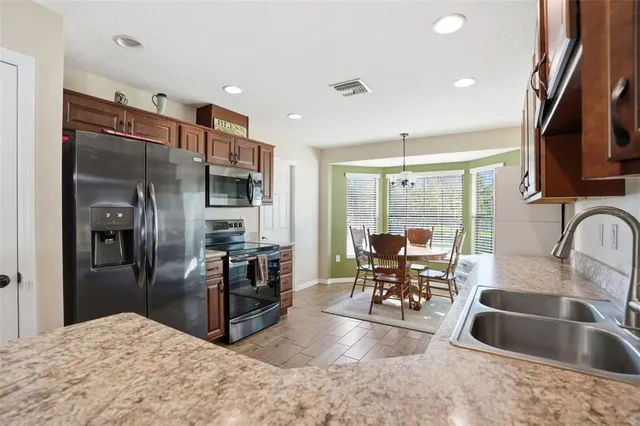 a kitchen with stainless steel appliances granite countertop a refrigerator and a sink