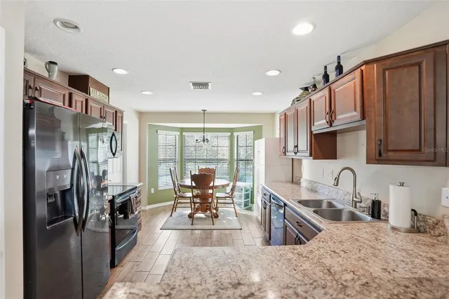 a kitchen with stainless steel appliances granite countertop a refrigerator stove microwave and sink
