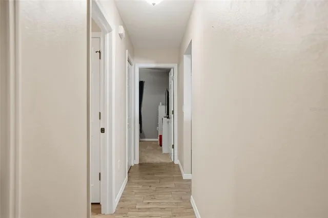 a view of a hallway with wooden floor