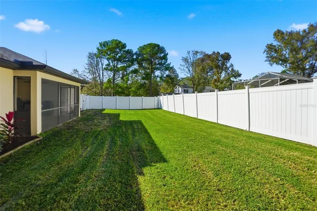a view of yard with swimming pool and trees