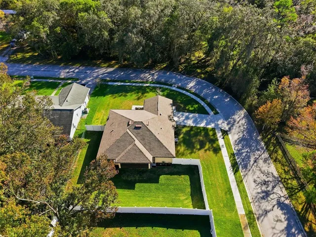 an aerial view of a house with swimming pool and garden