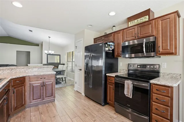 a kitchen with stainless steel appliances granite countertop a stove a sink dishwasher a refrigerator and a microwave oven