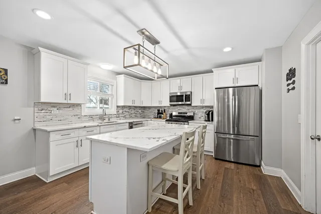a kitchen with a refrigerator a sink and cabinets