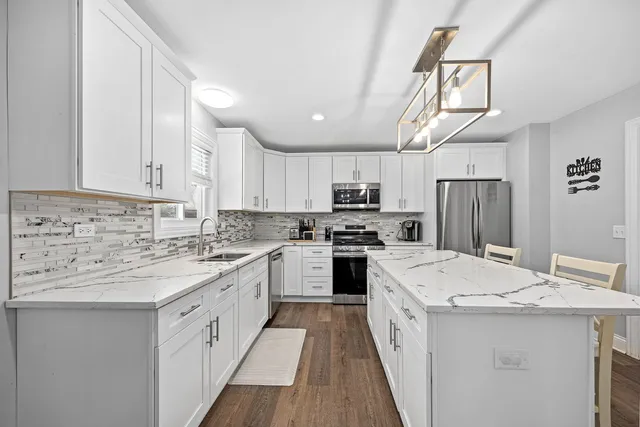 a kitchen with a sink a stove a refrigerator and cabinets