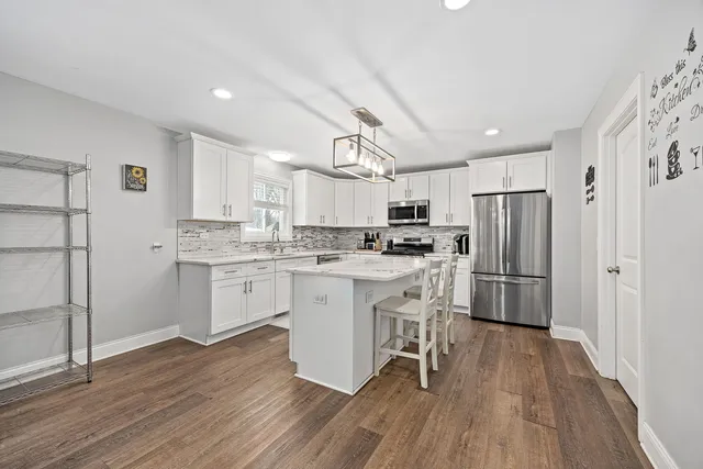 a kitchen with white cabinets and stainless steel appliances