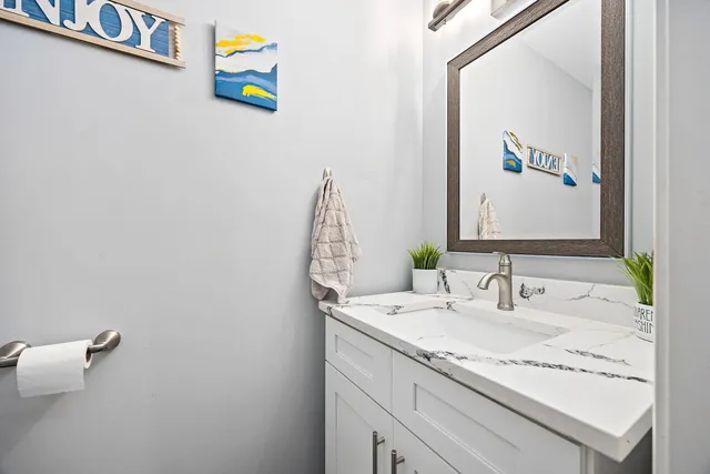a bathroom with a granite countertop sink and a mirror