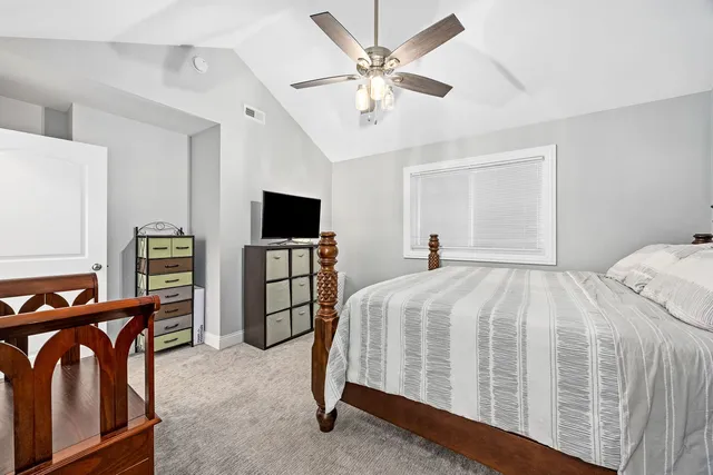 a bedroom with a bed and a flat tv screen on the dresser