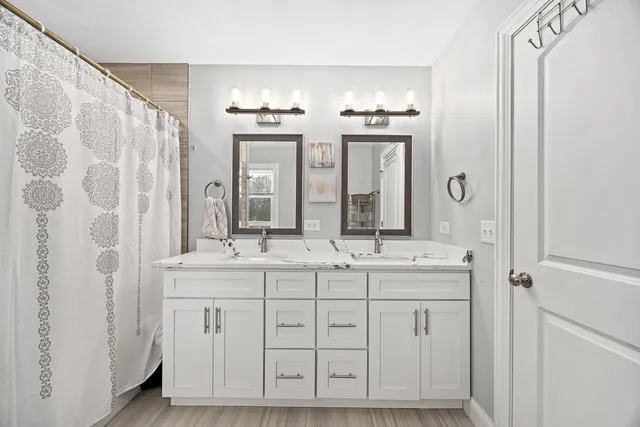 a bathroom with a double vanity sink and a mirror