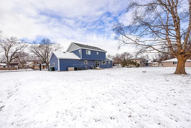a front view of a house with a yard covered in snow