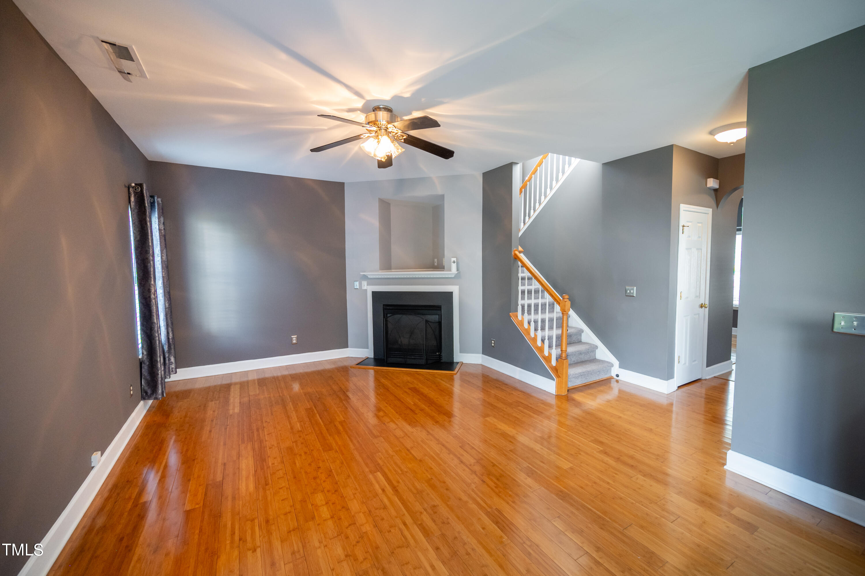 5308 Neuse Forest Road Raleigh, NC 27616 - Photo 5 of 26 a view of an empty room with wooden floor and a ceiling fan