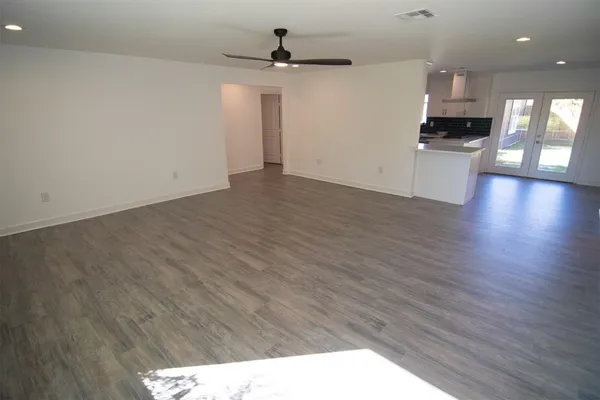 a kitchen with a sink a refrigerator and wooden floor