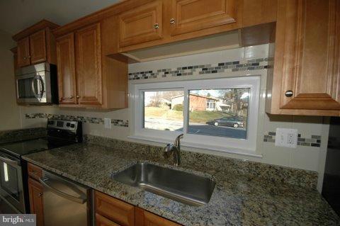 7405 Kathydale Road Pikesville, MD 21208 - Photo 1 of 29 a kitchen with granite countertop a sink and a stove next to a cabinet