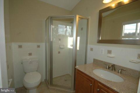 7405 Kathydale Road Pikesville, MD 21208 - Photo 20 of 29 a bathroom with a granite countertop toilet a sink and mirror