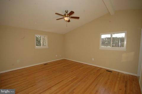 7405 Kathydale Road Pikesville, MD 21208 - Photo 22 of 29 a view of a room with wooden floor and a ceiling fan