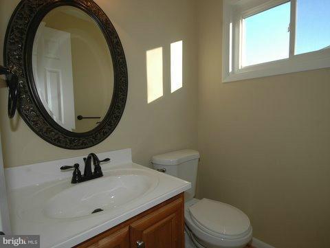 7405 Kathydale Road Pikesville, MD 21208 - Photo 9 of 29 a bathroom with a sink a mirror and a toilet