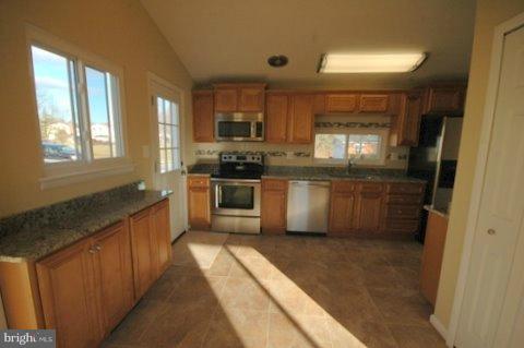7405 Kathydale Road Pikesville, MD 21208 - Photo 10 of 29 a large kitchen with a stove top oven sink and cabinets