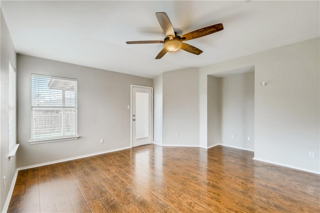 229 Killian Loop Hutto, TX 78634 - Photo 10 of 28 a view of an empty room with wooden floor and a window