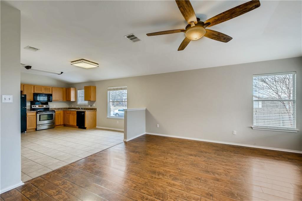 229 Killian Loop Hutto, TX 78634 - Photo 28 of 28 an empty room with wooden floor cabinet and windows