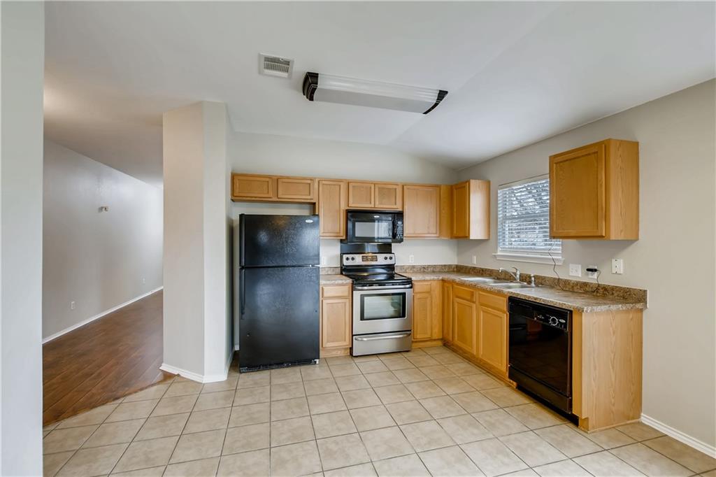 229 Killian Loop Hutto, TX 78634 - Photo 26 of 28 a large kitchen with stainless steel appliances granite countertop a stove and a refrigerator