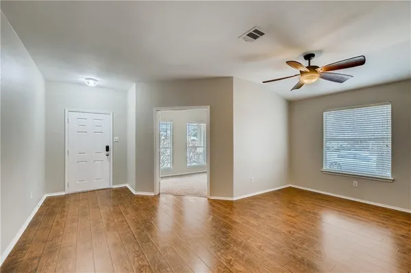 a view of a room with a ceiling fan and a hardwood