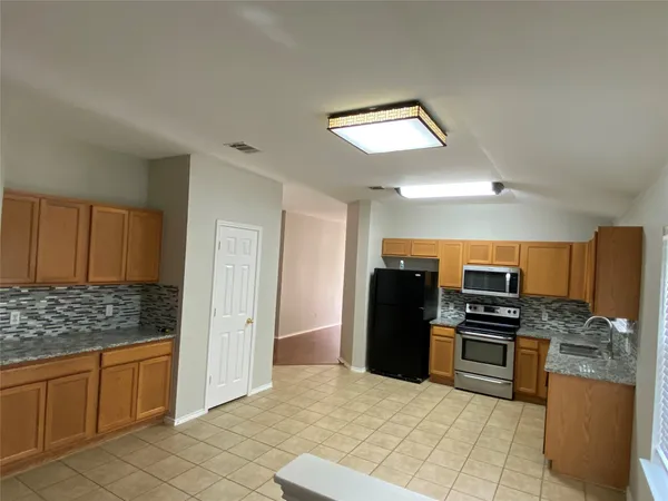 a view of a refrigerator in kitchen and a white kitchen
