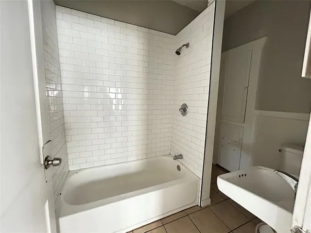 a white bath tub sitting next to a toilet