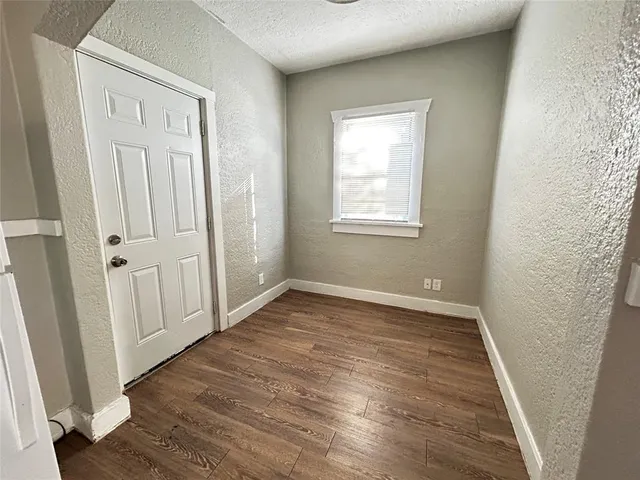 an empty room with wooden floor and window