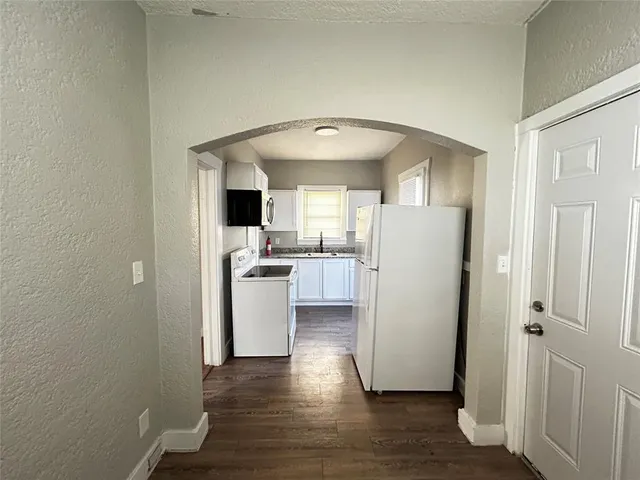 a view of a hallway with wooden floor and a living room