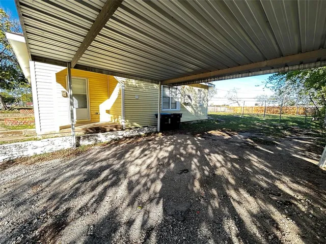 a backyard of a house with a garden and outdoor seating