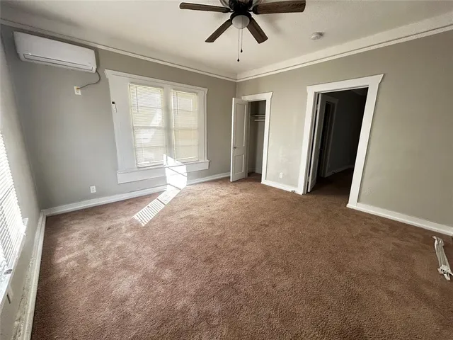a view of empty room with window and ceiling fan