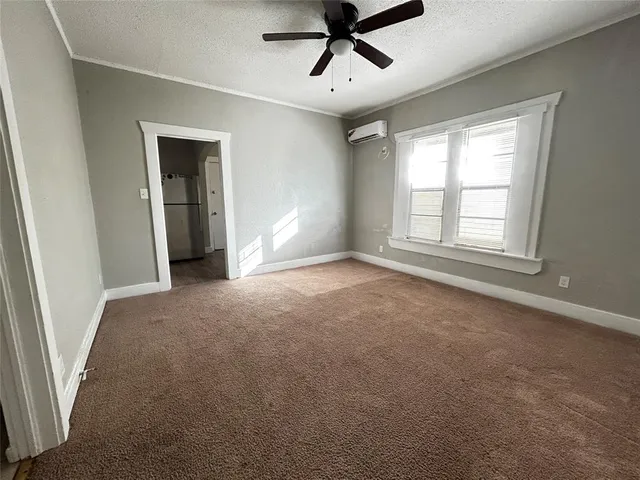 a view of a big room with windows and chandelier fan