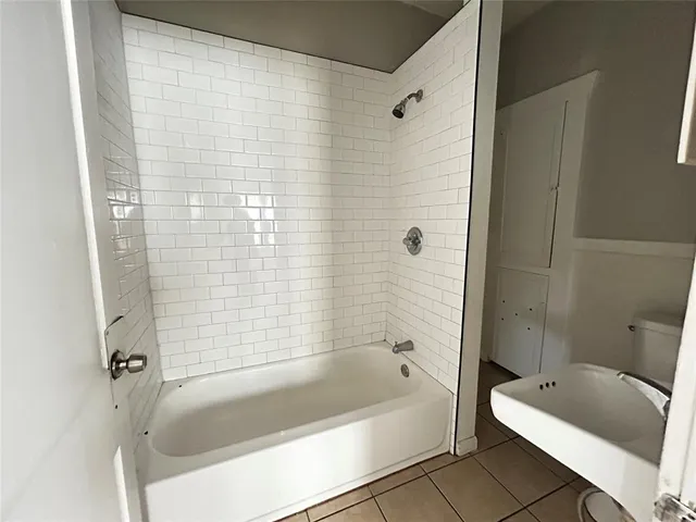 a bathroom with a tub a sink and a shower