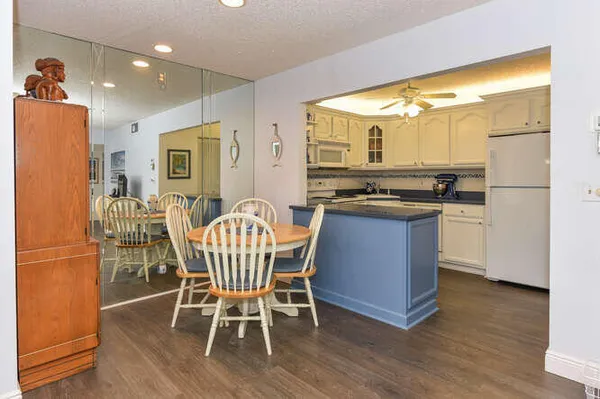 a kitchen with stainless steel appliances granite countertop dining table chairs and wooden floor