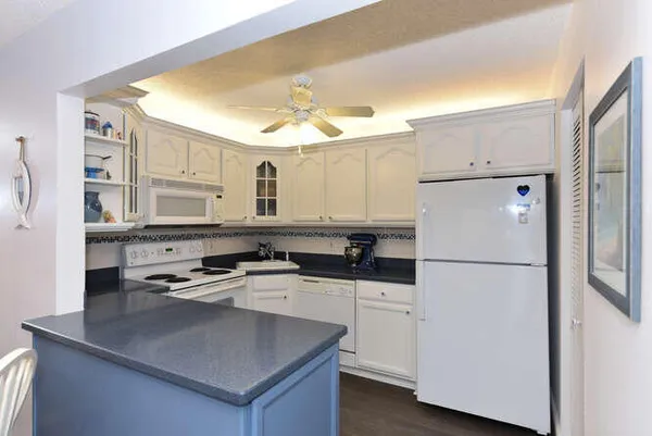 a kitchen with appliances a sink and cabinets
