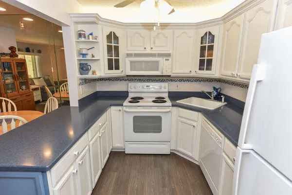 a kitchen with a white cabinets and wooden floor