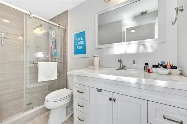 a bathroom with a sink a toilet and shower