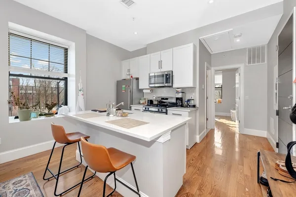 a kitchen with a sink a counter top space and stainless steel appliances