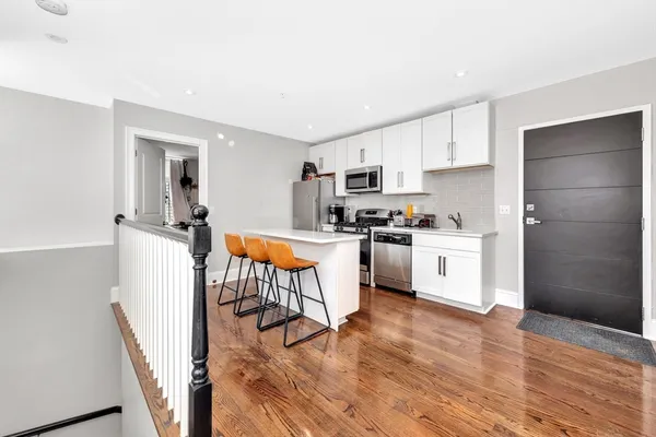 a kitchen with a sink a refrigerator and white cabinets