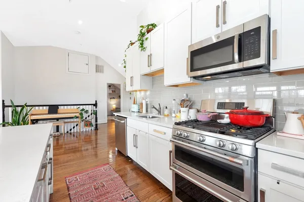 a kitchen with stainless steel appliances a stove microwave and cabinets