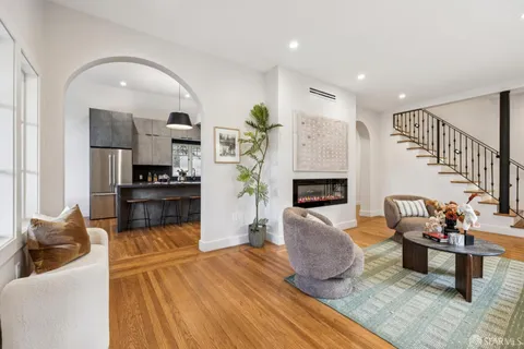 a kitchen with a table chairs stove and wooden floor