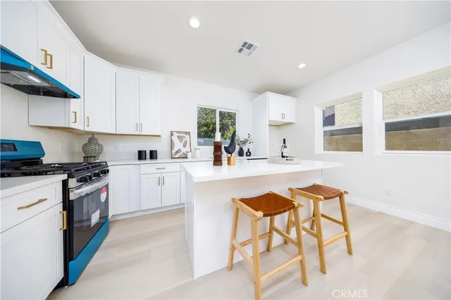 a kitchen with stainless steel appliances kitchen island granite countertop a sink and cabinets