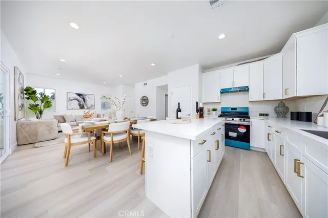 a large white kitchen with lots of white cabinets appliances and furniture